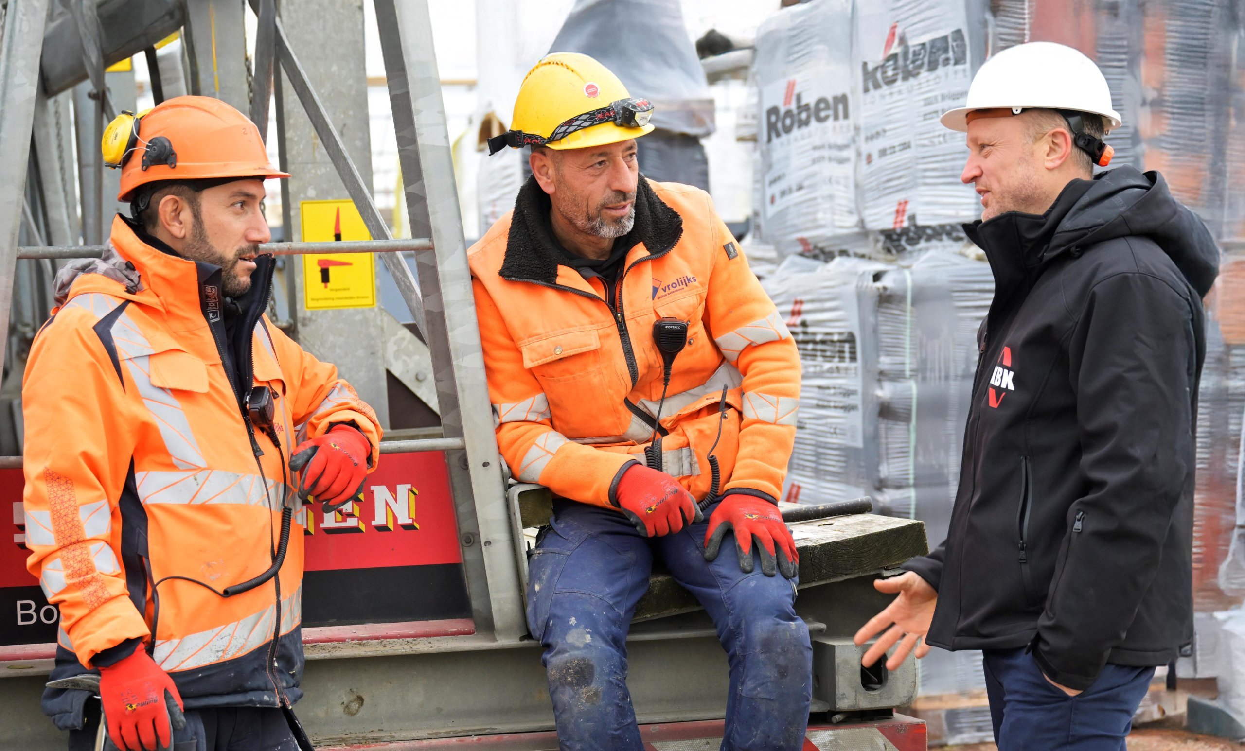 Hoofd Inkoop KBK bouwgroep in overleg met onderaannemers lachend